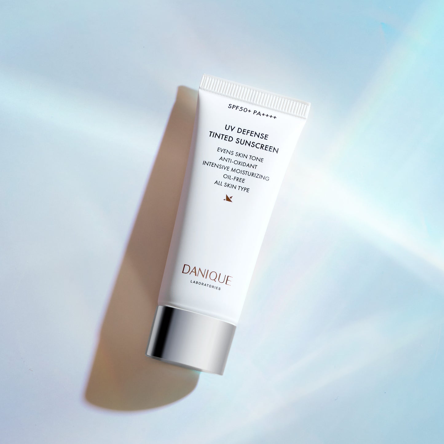 Tube of Danique UV Defense Tinted Sunscreen on a gradient background